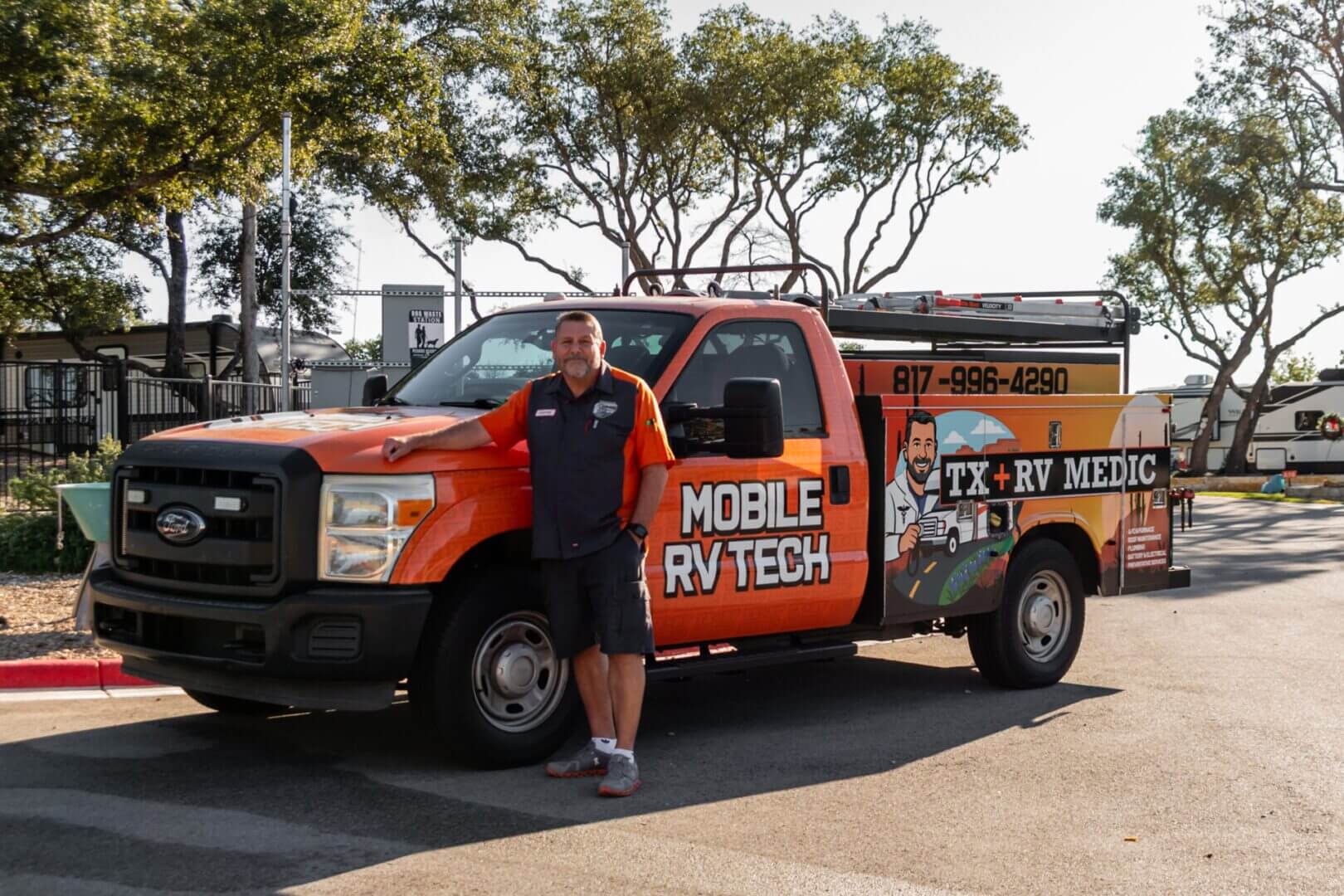 Man leaning on orange mobile RV tech truck